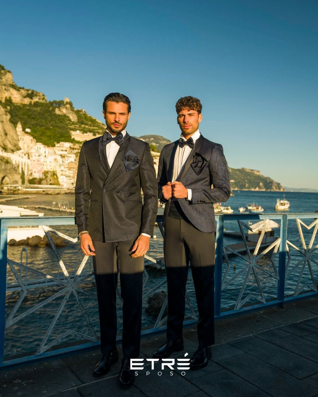 Due uomini in smoking sono in piedi uno accanto all'altro su un molo.