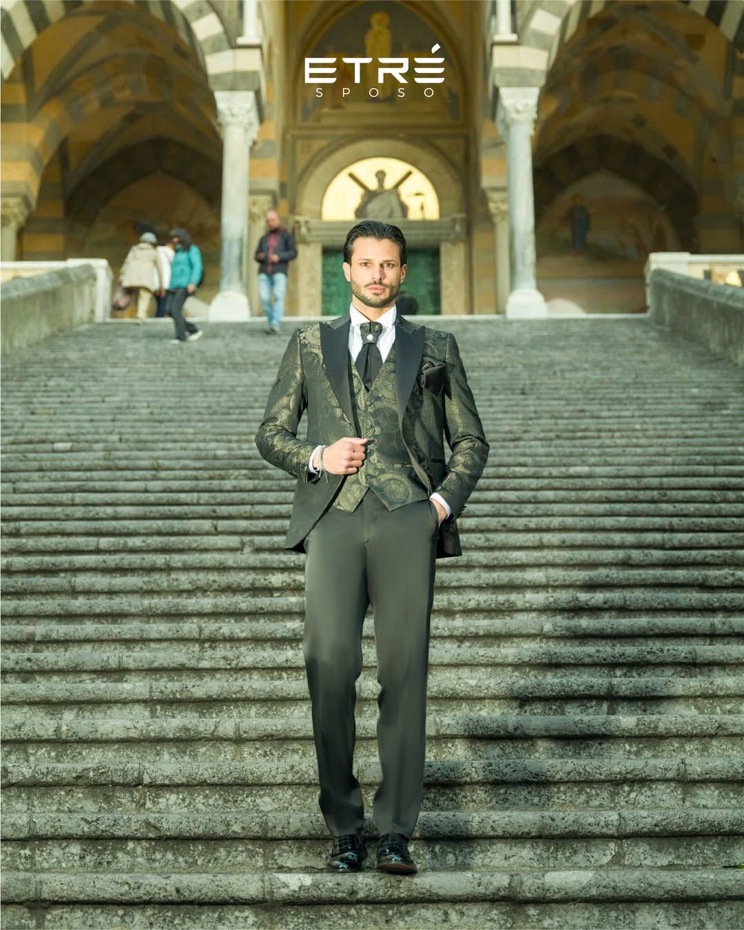 Un uomo in giacca e cravatta è in piedi su una rampa di scale.