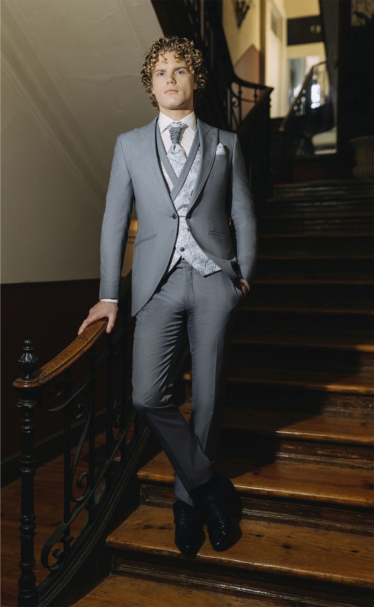 Un uomo in giacca e cravatta è in piedi su una rampa di scale.