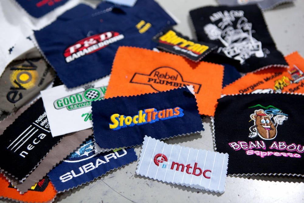 Close-up of Embroidered Company Logos on Fabric Patches — Workwise Clothing Forster in Forster, NSW