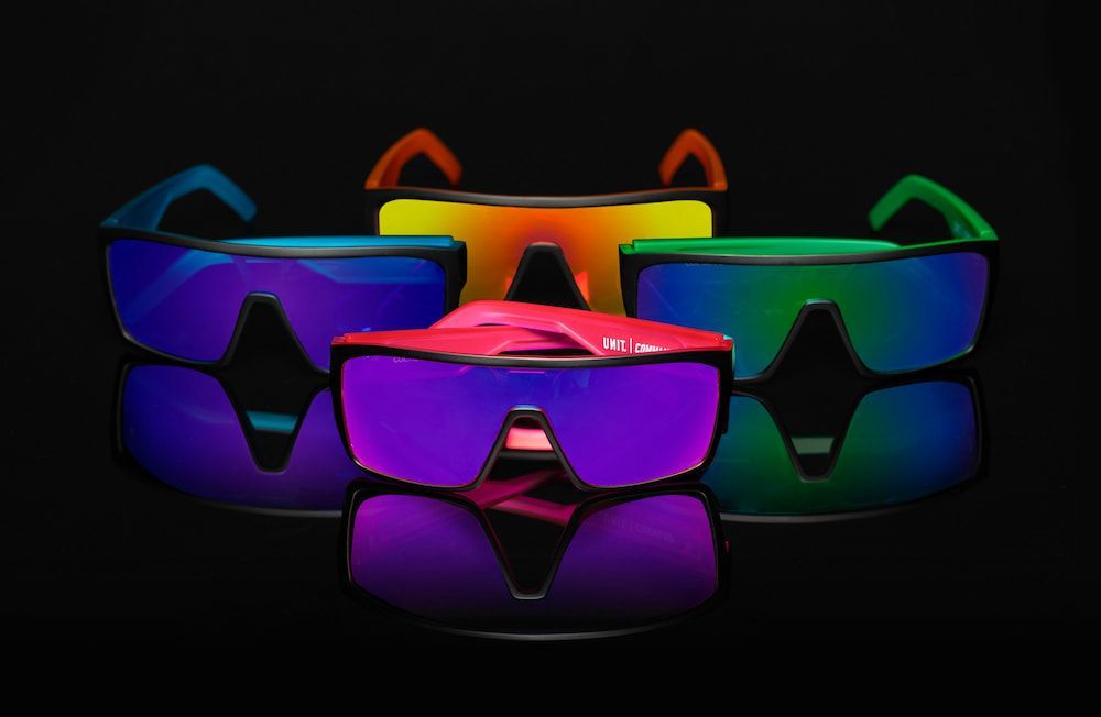Colorful Mirrored Sunglasses on Black Background — Workwise Clothing Forster in Forster, NSW