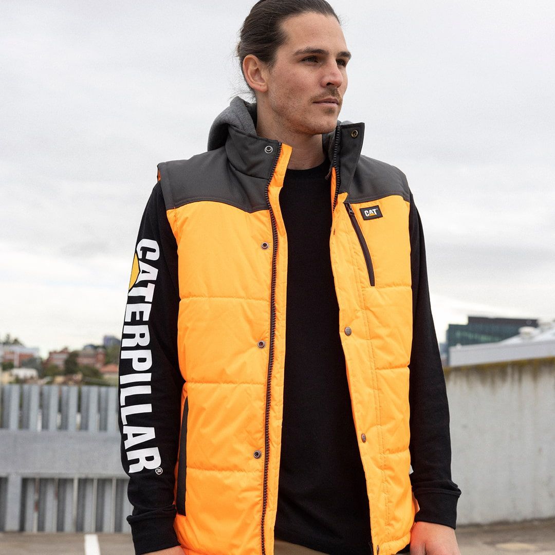 Man in Orange Caterpillar Vest and Black Shirt — Workwise Clothing Forster in Forster, NSW