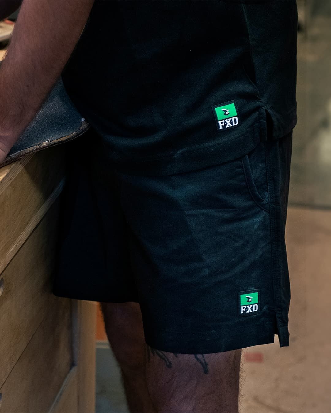 Person Wearing Black Shorts With a Green Logo on the Side — Workwise Clothing Forster in Forster, NSW