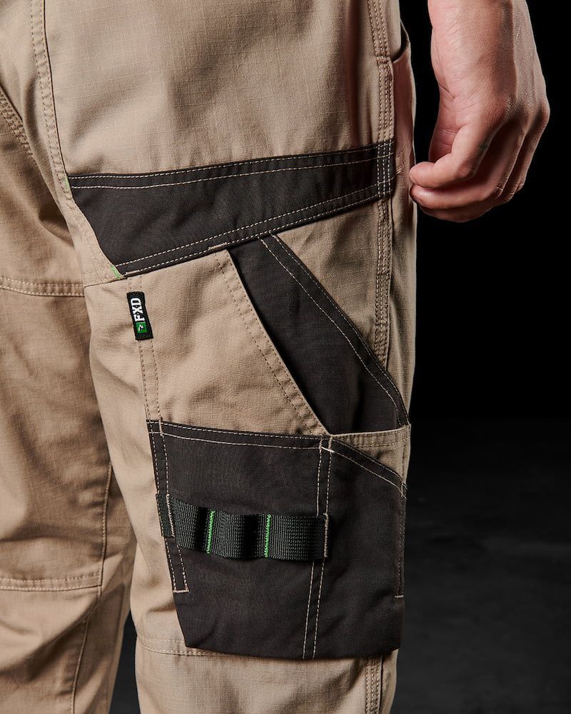 Tan Work Pants With Black Accents and Pockets, Featuring a Hand in Pocket — Workwise Clothing Forster in Forster, NSW