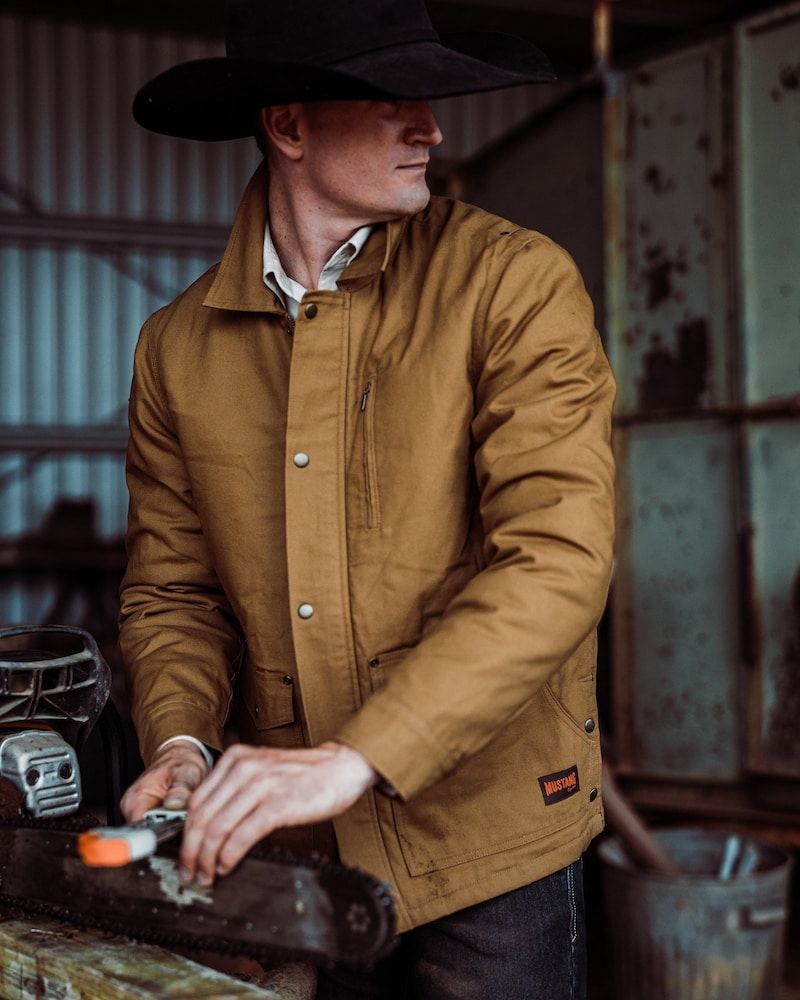 Man in Cowboy Hat and Brown Jacket Working With Tools — Workwise Clothing Forster in Forster, NSW