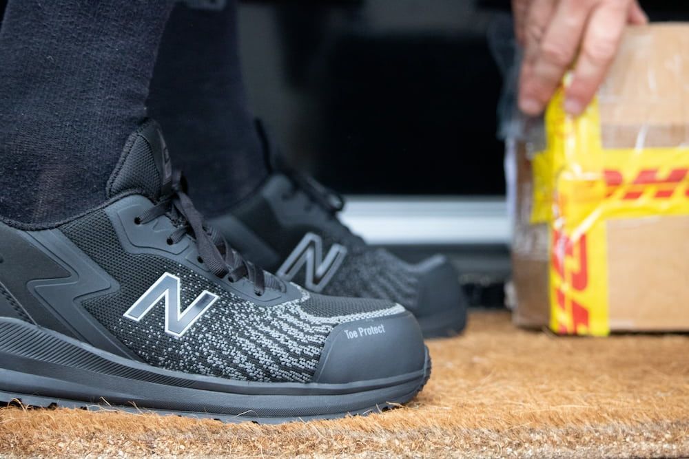 Black New Balance Work Shoes Next to a Dhl Package — Workwise Clothing Forster in Forster, NSW