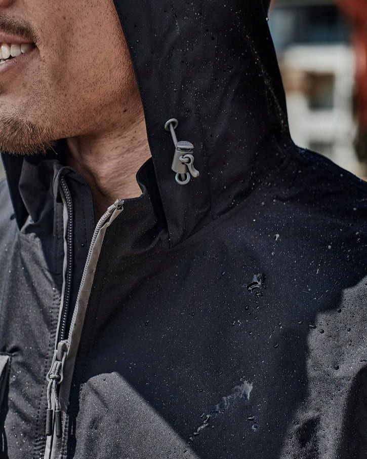 Man in Black Hooded Jacket, Smiling Slightly — Workwise Clothing Forster in Forster, NSW