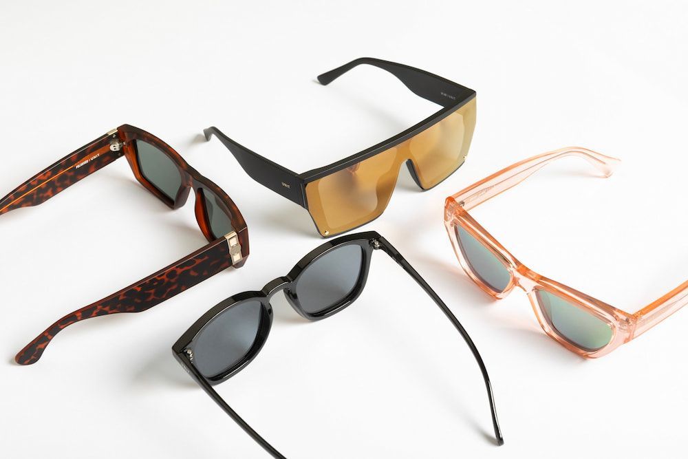 Five Pairs of Sunglasses in Various Styles and Colours, on a White Background — Workwise Clothing Forster in Forster, NSW