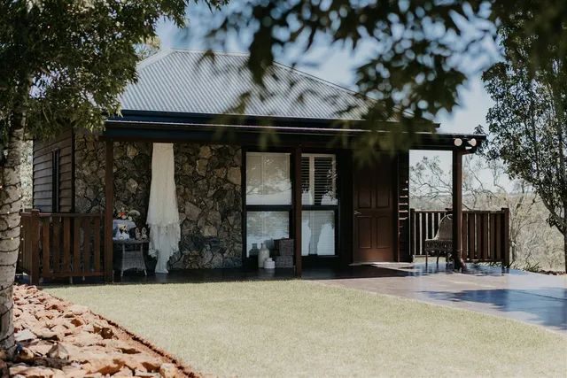 A stone house with a hanging dress on the porch