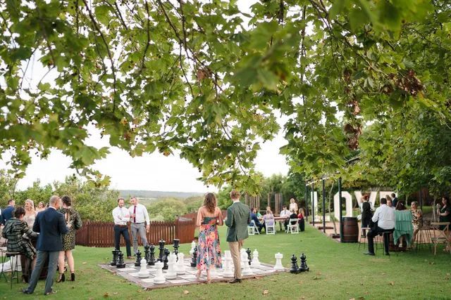 A group of people are playing a game of chess in a park.