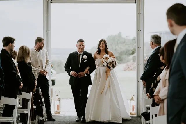 A bride and groom are walking down the aisle at their wedding.