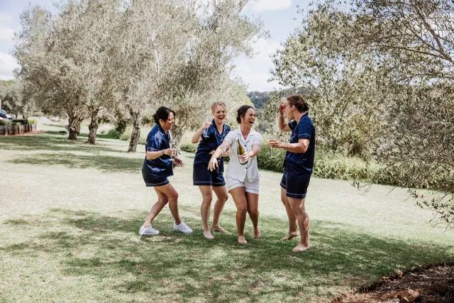 A group of women are standing in a field laughing.
