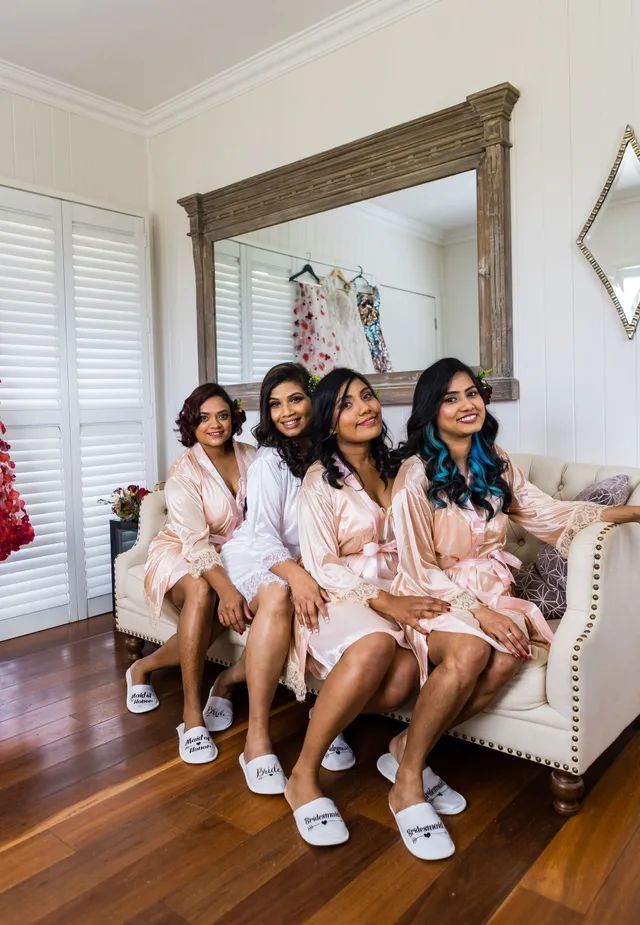 A group of women are sitting on a couch in front of a mirror.