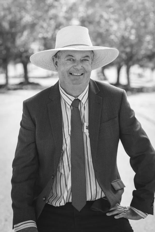 A man in a suit and tie is wearing a cowboy hat.