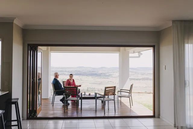 A man and a woman are sitting at a table on a porch.