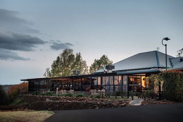 A large house with a lot of windows is sitting on top of a hill.