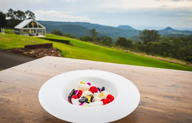 A bowl of fruit is sitting on a wooden table.