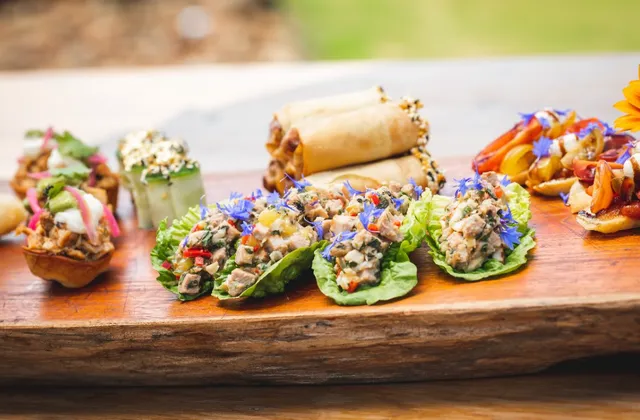 A wooden cutting board topped with a variety of food on a table.