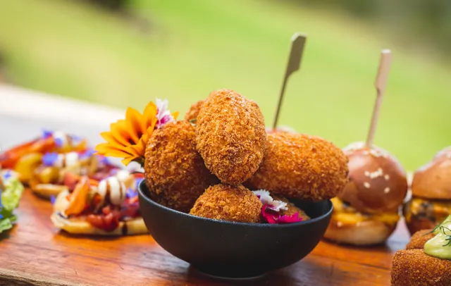 A bowl of fried food is sitting on a wooden table.