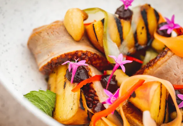 A close up of a plate of food with flowers on it.