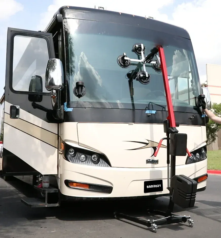 A rv with a windshield being replaced on a stand