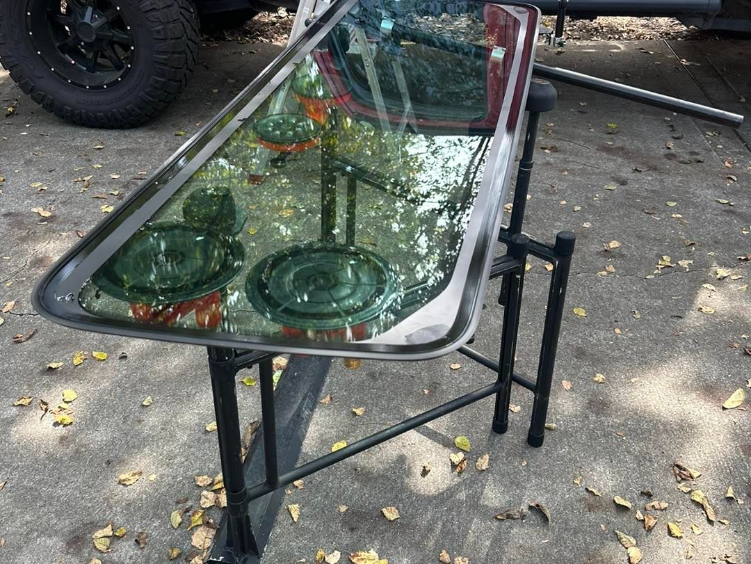 A piece of glass is sitting on top of a metal table.