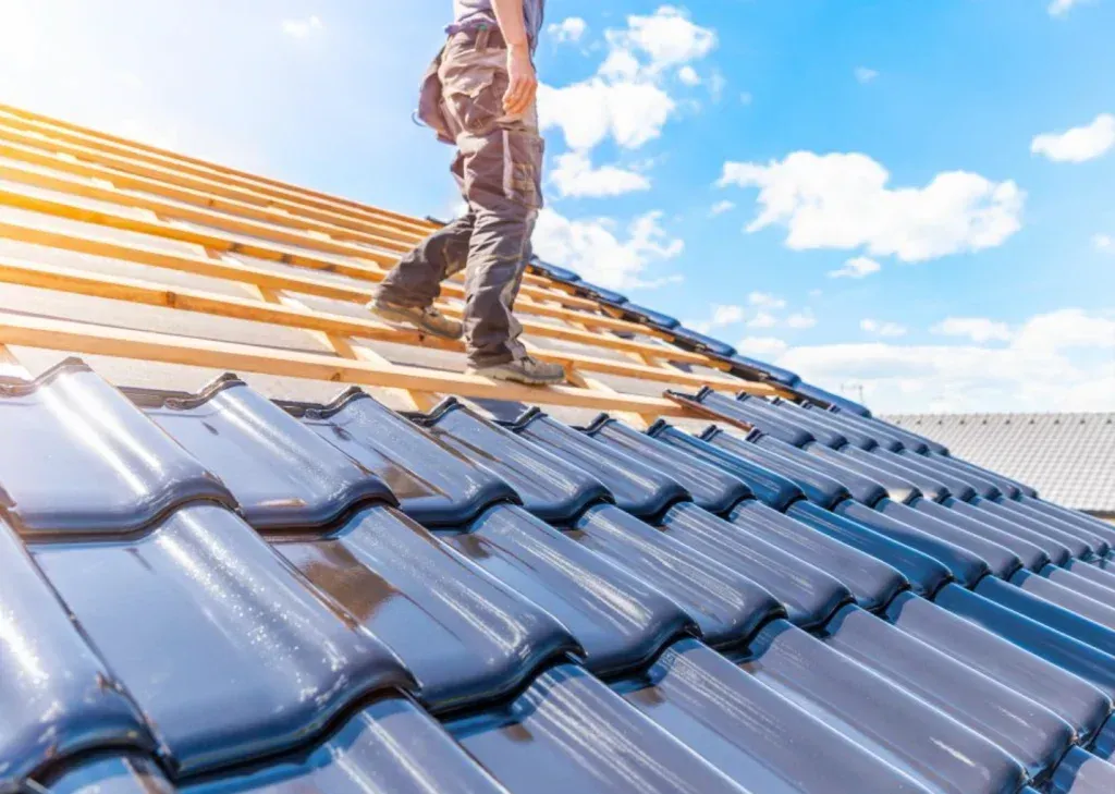 A roofer on a roof with a blue sky in the background
