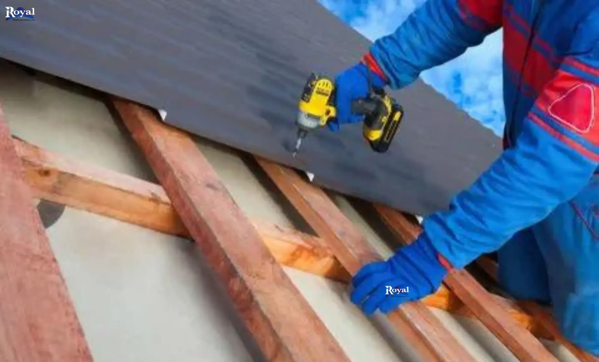 A man in blue overalls and a blue overall is working on a roof