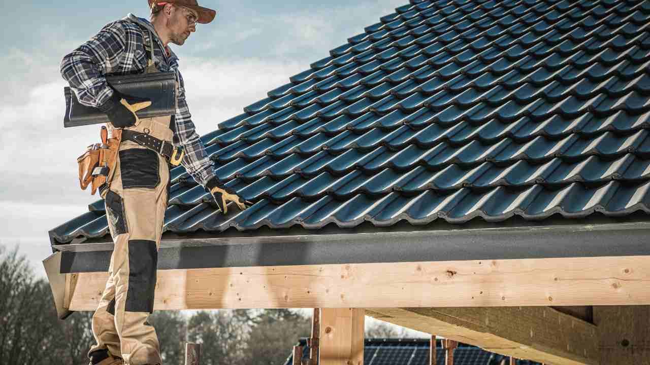 A man standing on the roof of a house.