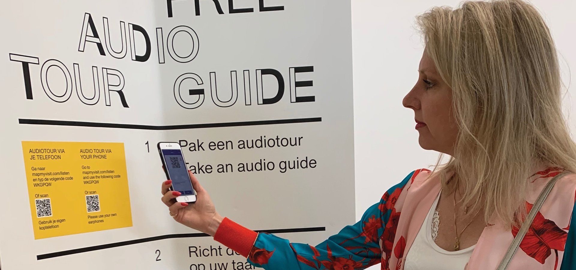 Marlise Meuter using her mobile phone to scan the QR code for the mobile website audio tour