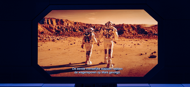 A still of a movie of two people walking on mars in a very dark room