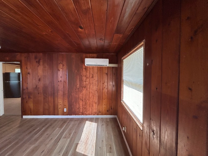 Interior of a room with wood paneling on the walls and ceiling. 