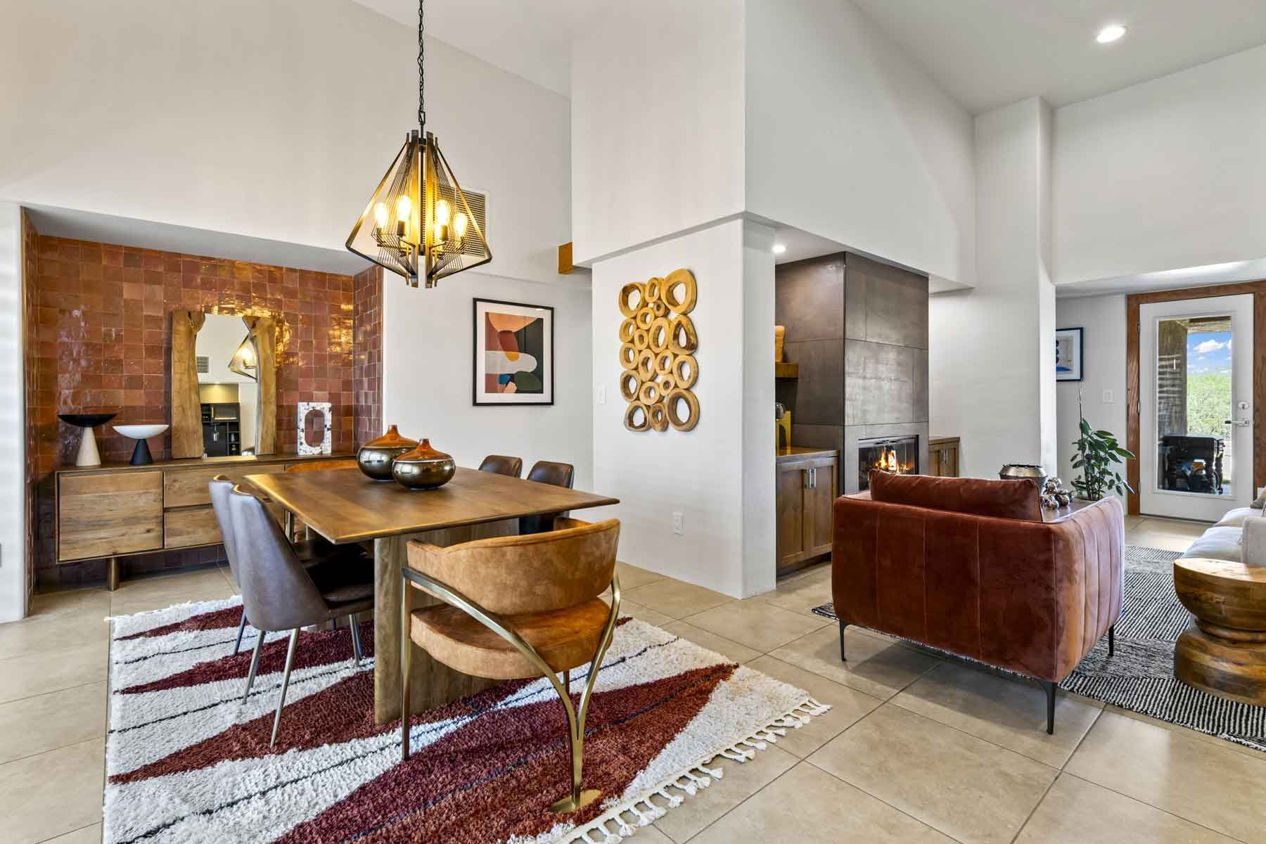 Modern kitchen and living room with orange couch, granite countertops, and a stainless steel sink.