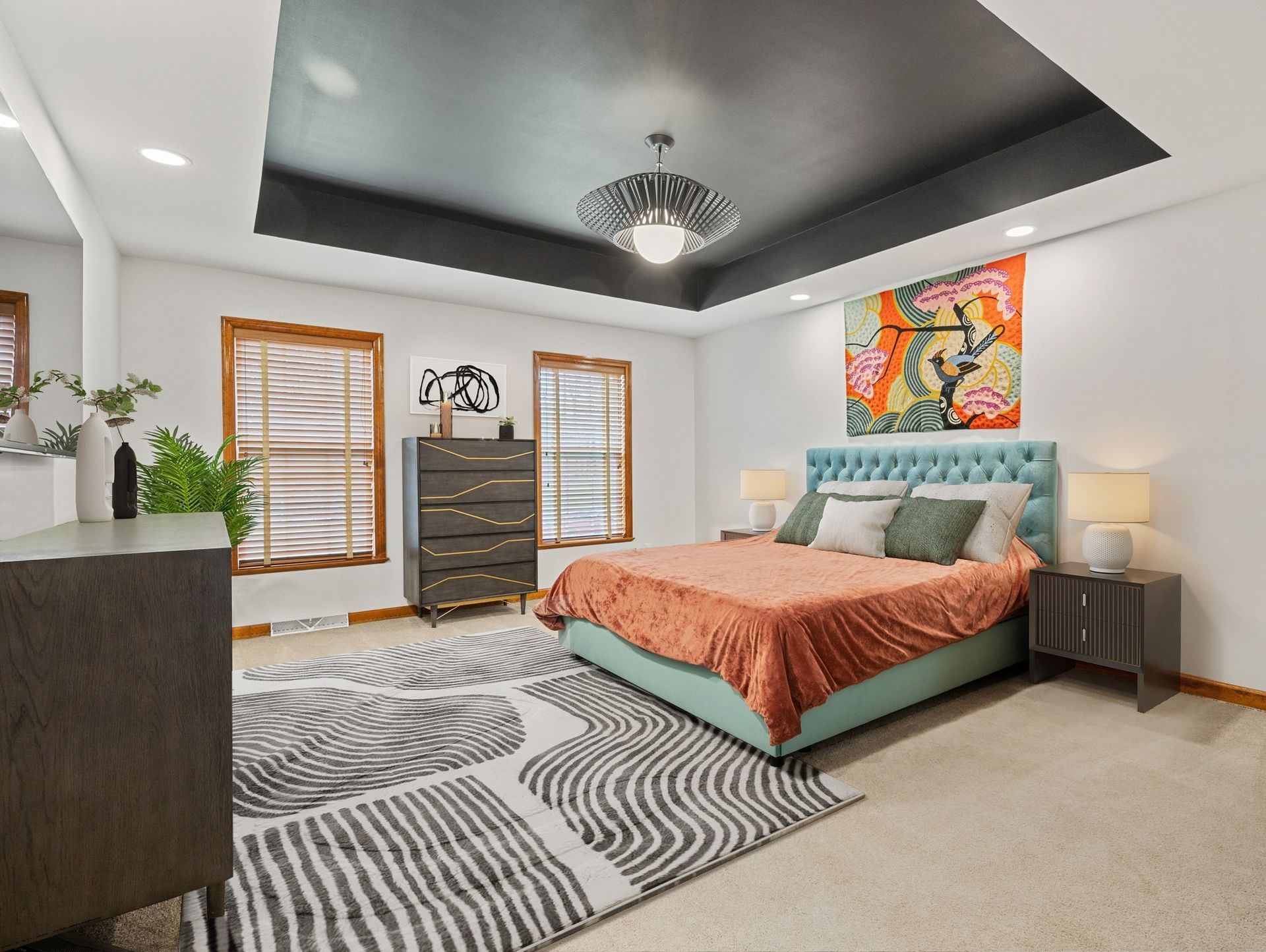 Bedroom with teal bed, orange blanket, gray dresser, and a black ceiling.