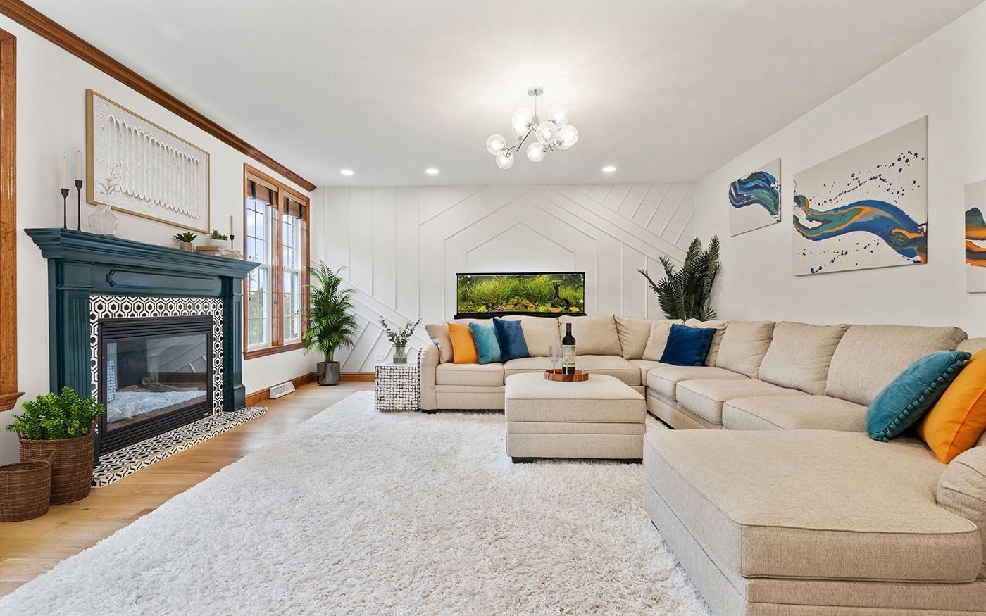 Cozy living room with a white sectional, teal fireplace, and a fish tank, with white walls and a shag rug.