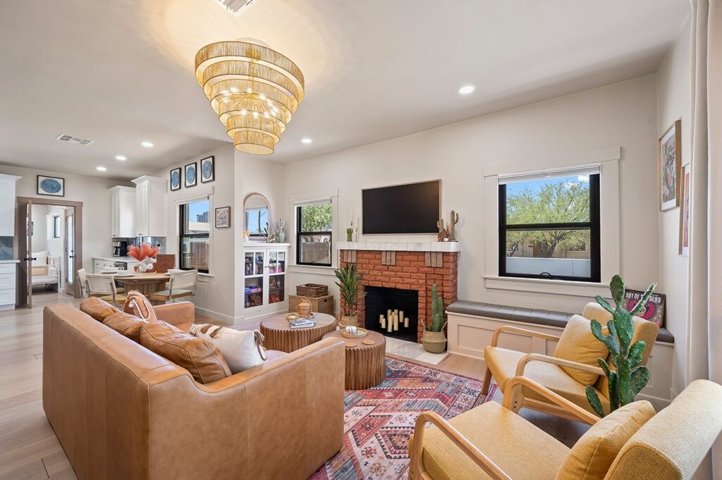 Living room with a brown leather sofa, fireplace, and area rug.