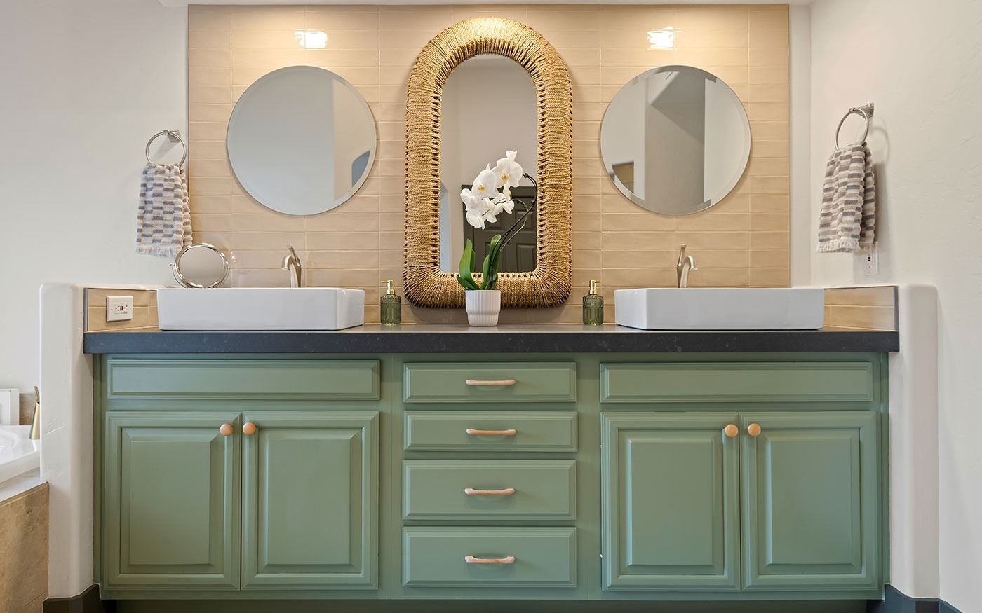 Green bathroom vanity with gold accents, three mirrors, and sinks.