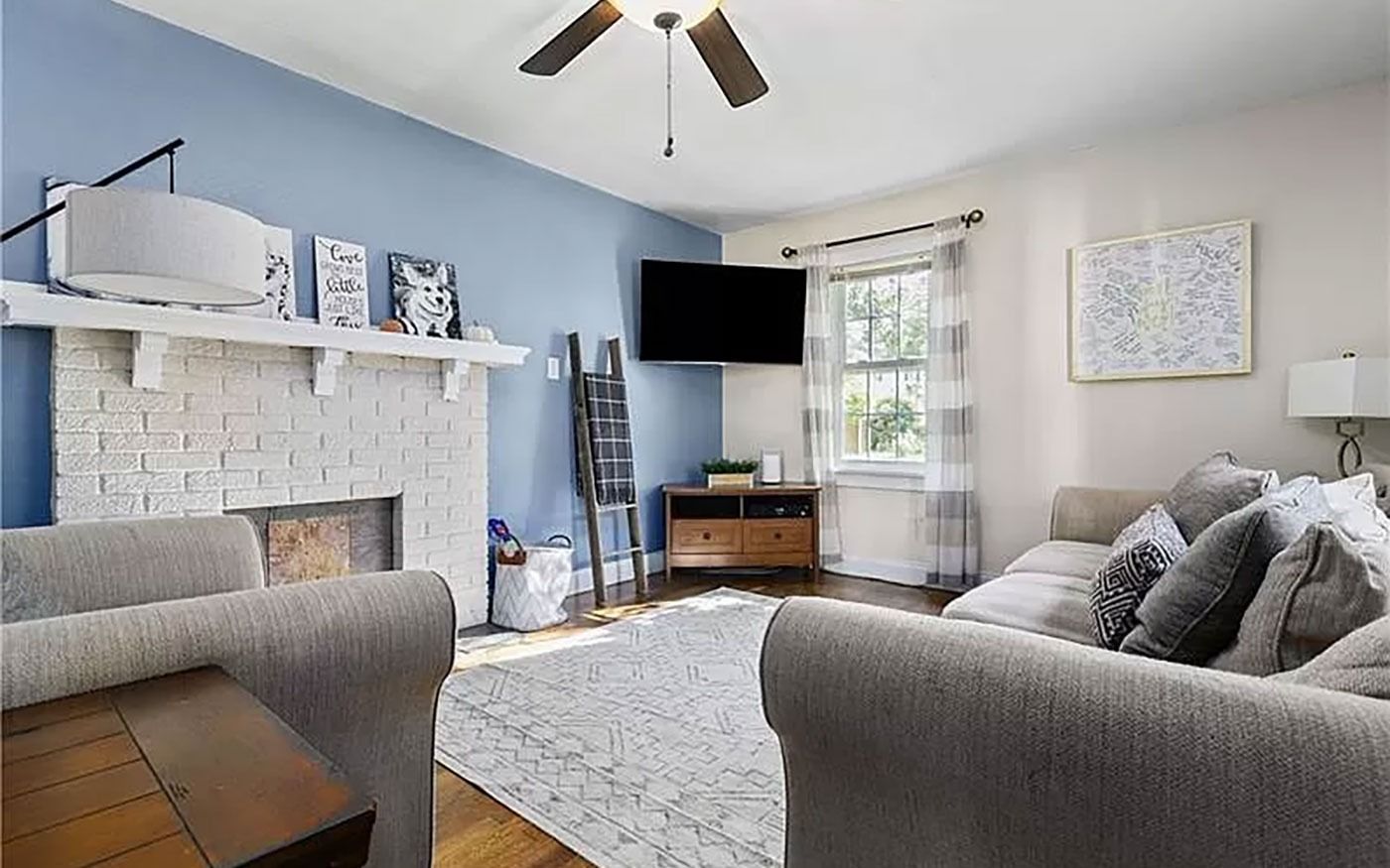 Living room with fireplace, blue accent wall, sofa, and TV.