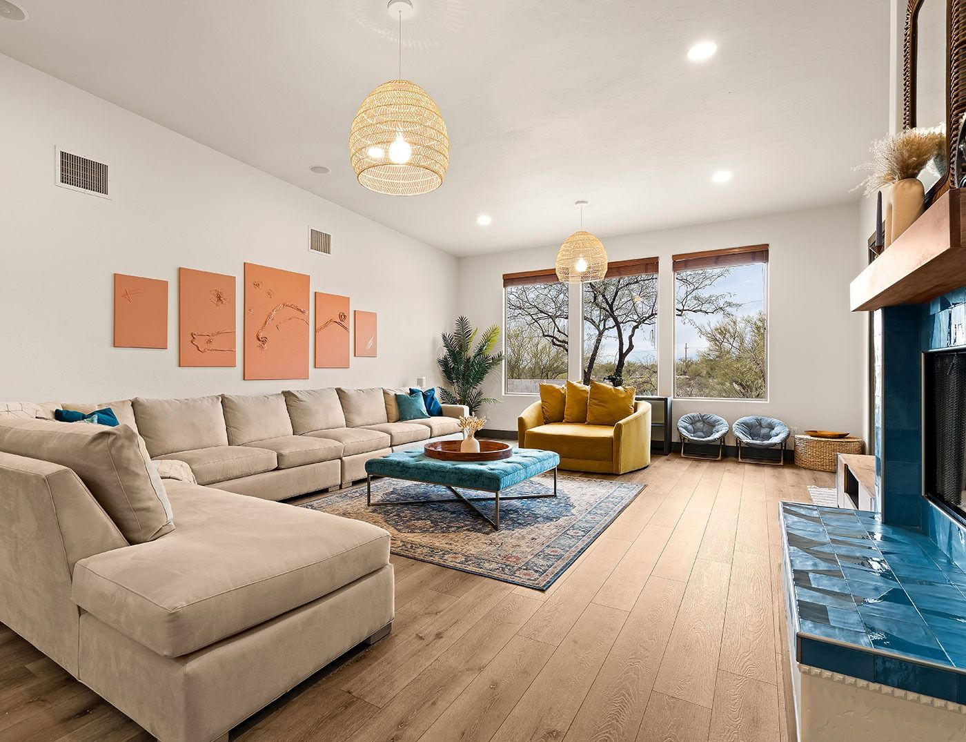 Spacious living room with sectional sofa, blue accents, and large windows with a scenic view.