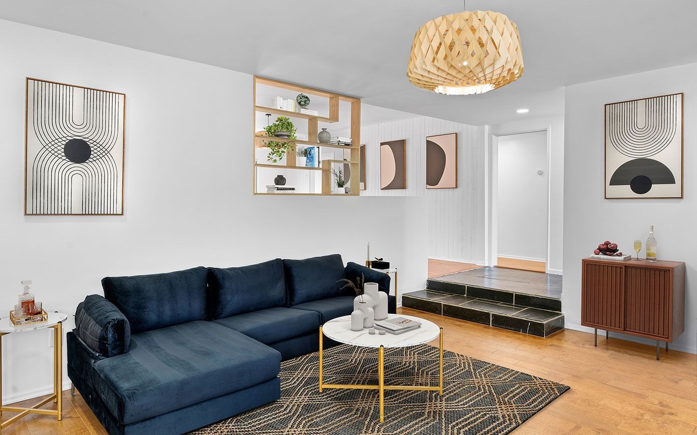 Living room with navy sectional, artwork, and gold accents.