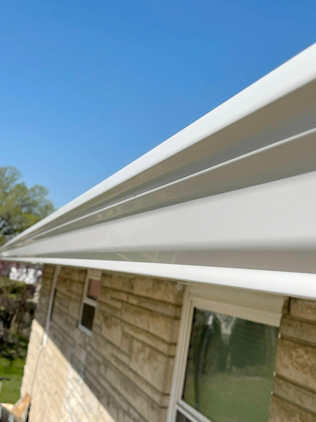 A white gutter is on the side of a house.