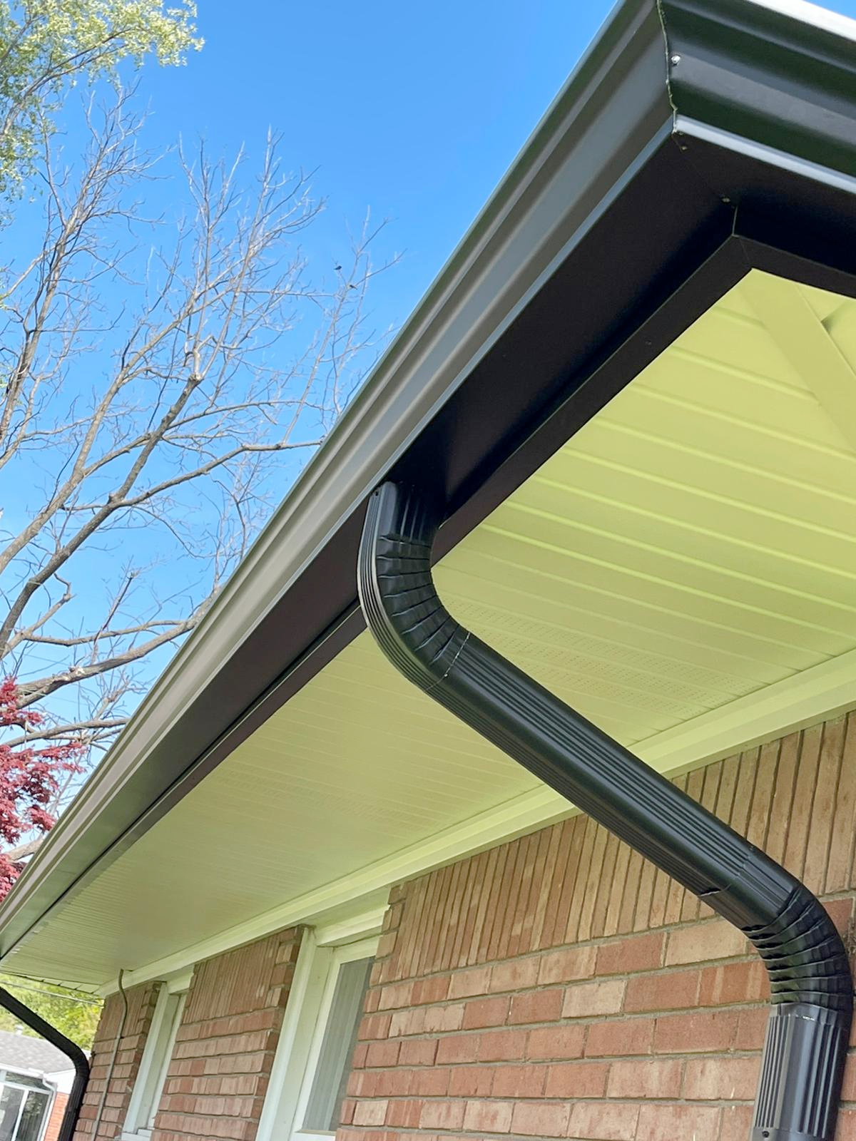 A close up of a black gutter on a brick house.
