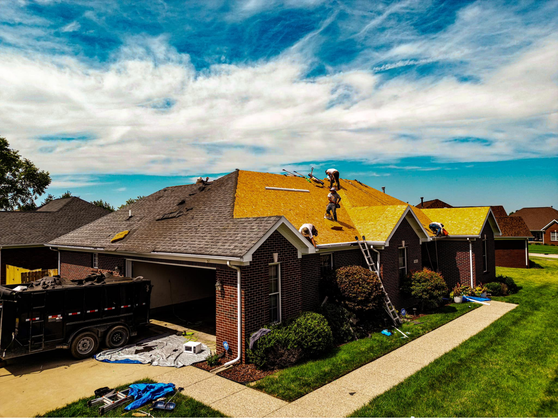 A roofer is working on the roof of a house.