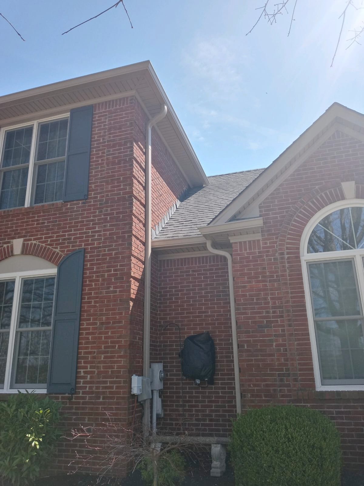 A brick house with a gutter on the side of it.