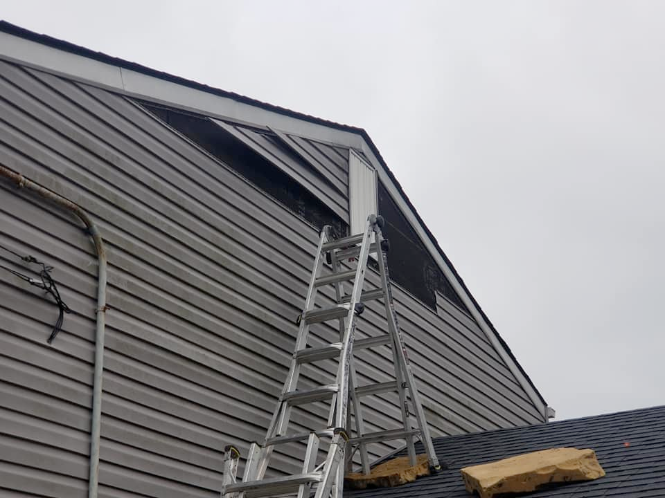 A ladder is sitting on the roof of a house.