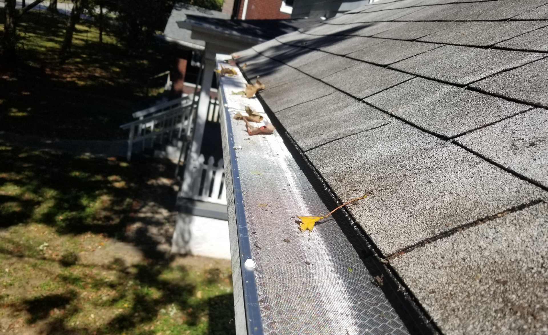 a gutter on a roof with leaves on it