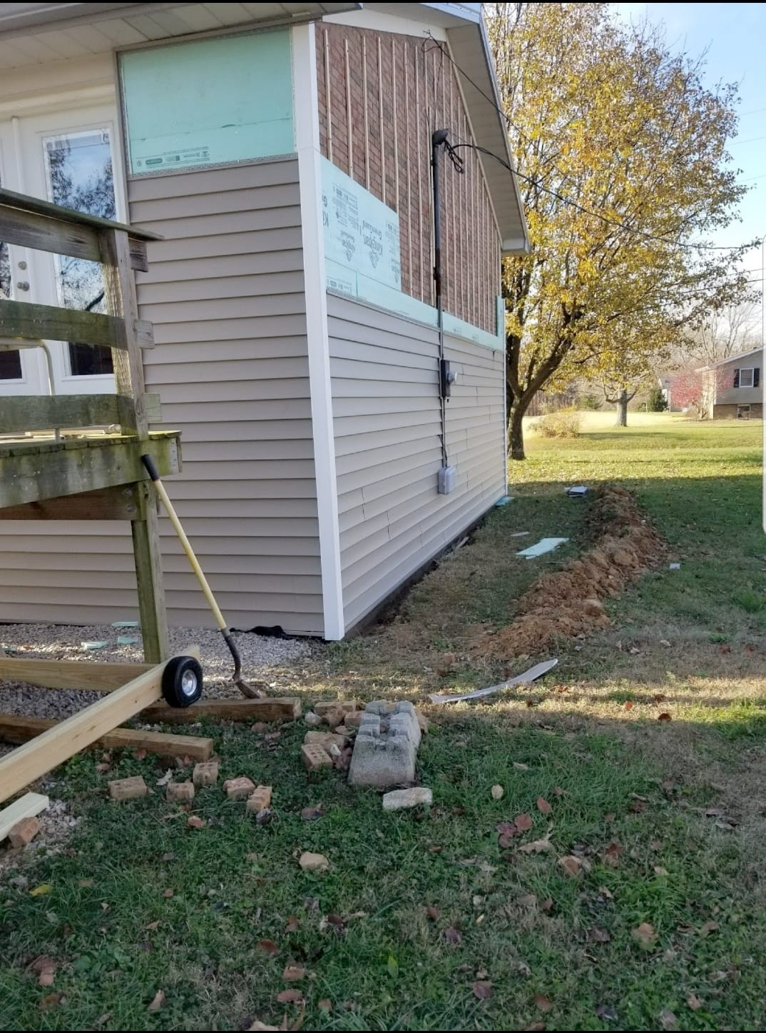 A house is being remodeled with siding and a fence.