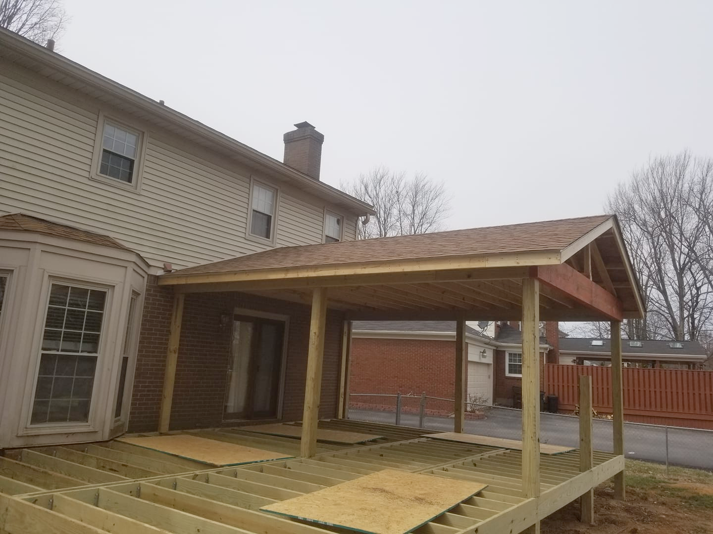 A wooden deck is being built on the side of a house