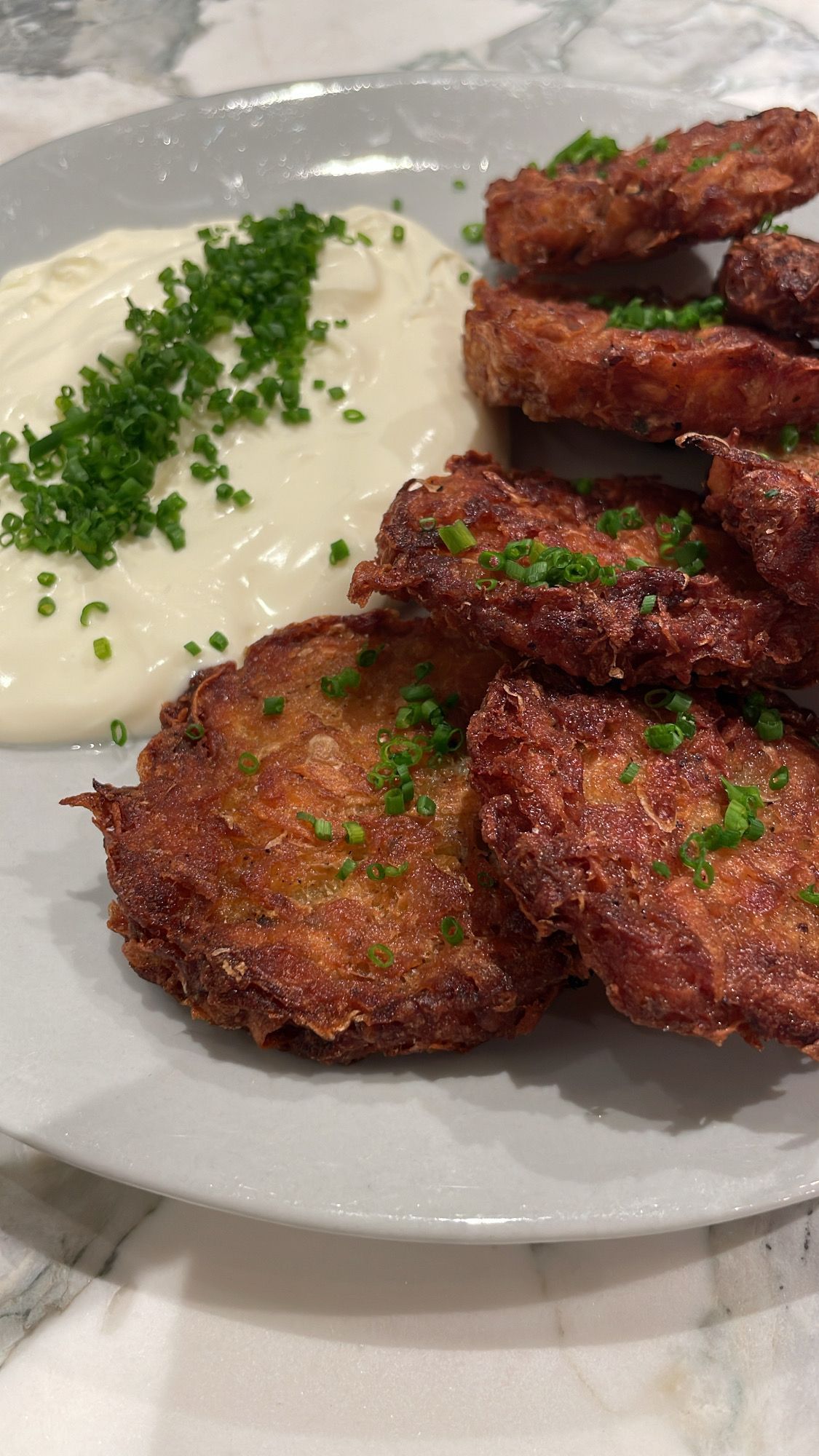 Potato Latkes topped with Chives and Served with a side of Creme Fraiche 