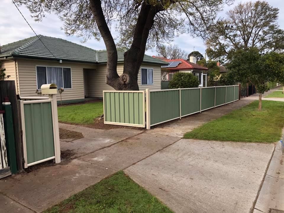 A house with a green fence in front of it
